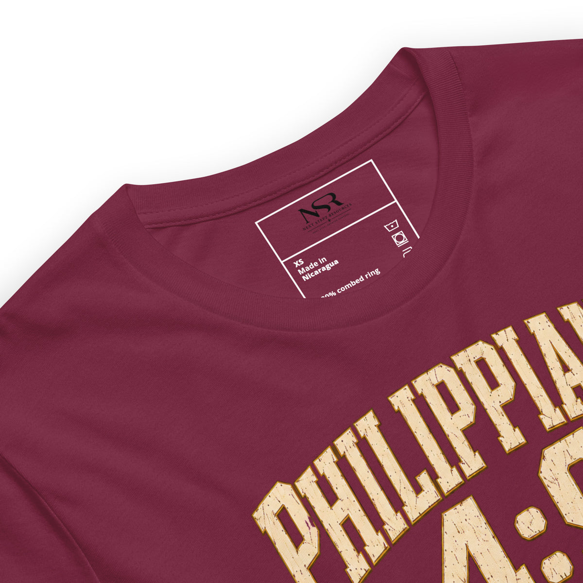 Close-up of a maroon crewneck t-shirt with distressed gold lettering reading 'PHILIPPIA' and '4:00' on the front, showing the inner neck label with 'NSX' branding.